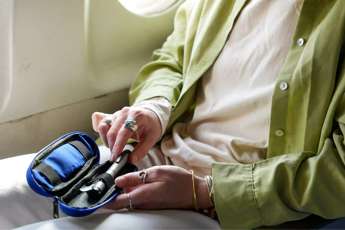 Woman with a insulinpen in an airplane in a medicooler